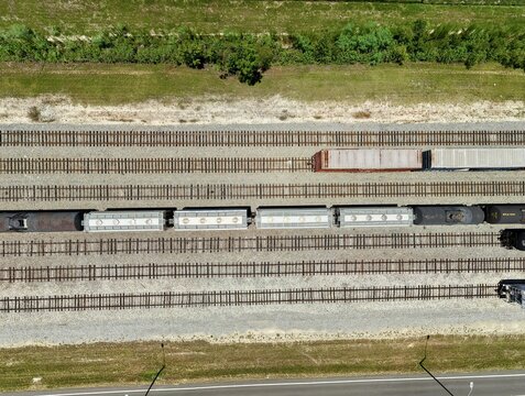 Aerial view of Georgia-Pacific Palatka Operations rail yard with freight train cars on parallel tracks, gravel ballast, and green vegetation in Palatka, Florida, United States.