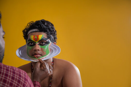Kathakali dancer getting his final stages of makeup done.