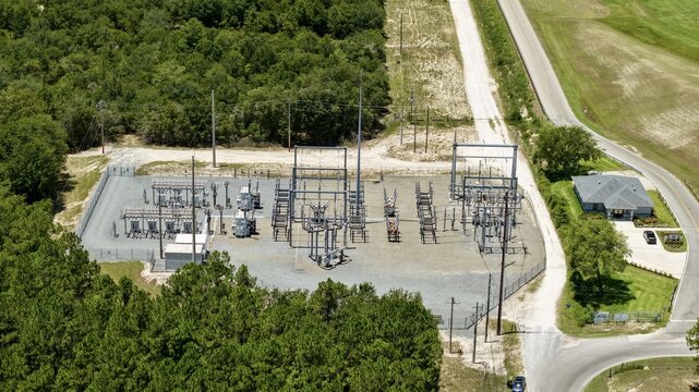 Aerial view of the Georgia-Pacific Palatka Operations electrical substation, featuring industrial equipment and metal structures surrounded by dense forest in Palatka, Florida, United States.