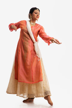 Graceful kathak dancer performing over a white background. 