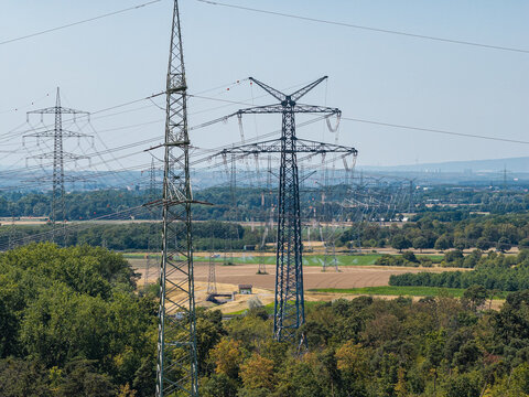 Aerial view of the Amprion-Umspannwerk substation with high-voltage electricity pylons and transmission lines stretching across the rural landscape of Pfungstadt, Hessen, Germany.