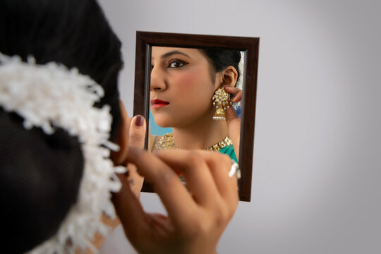 Kathak dancer checking her earrings in the mirror. 