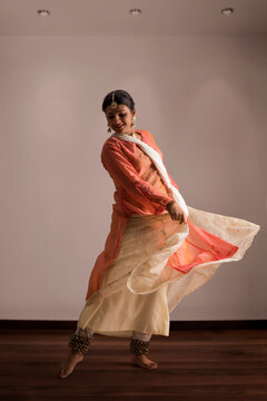 Beautiful kathak dancer performing gracefully at home.