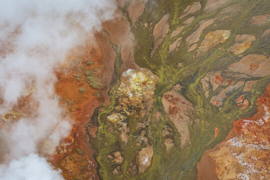 Aerial view of Gunnuhver geothermal area with steaming vents, vibrant mineral deposits, and colorful mud pools in Grindavikurbaer, Iceland.