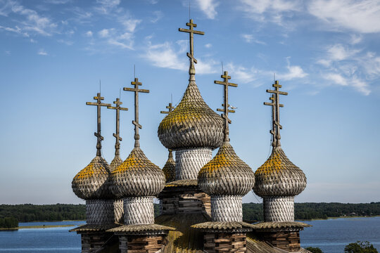 Aerial view of the historic wooden onion domes and crosses of the Kizhi Pogost church complex set against the blue sky and Lake Onega in Petrozavodsk, Republic of Karelia, Russia.