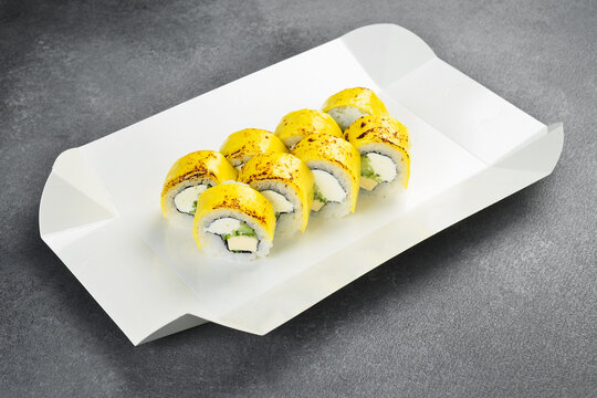 Japanese cheddar cheese sushi roll set isolated on white background. Delicious rolls filled with cream cheese and cucumber topped with melted cheese. Tasty seafood.