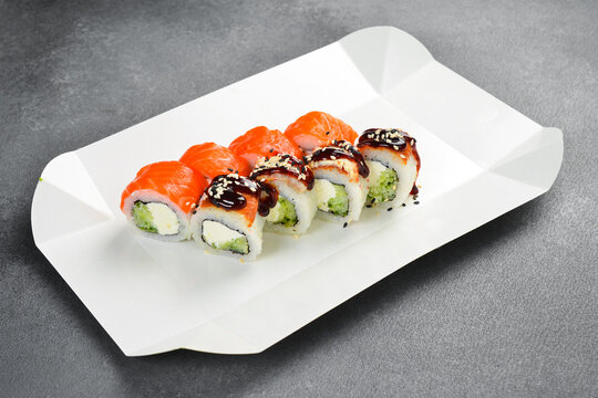 Fresh salmon Philadelphia rolls and unagi eel sushi rolls isolated on white background. Gourmet Japanese seafood set sprinkled with sesame seeds. Delicious food.