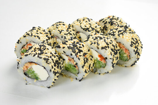 Japanese sushi roll set with sesame seeds served in white paper takeaway tray. Tasty rolls filled with cream cheese and cucumber. Fresh seafood.
