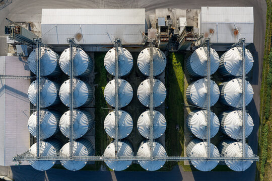 Aerial view of large grain bins arranged in rows at a storage facility in Poland.