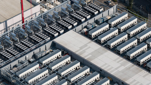 Aerial view of a large industrial data center rooftop featuring rows of cooling units and HVAC chillers in Slough, England, United Kingdom.
