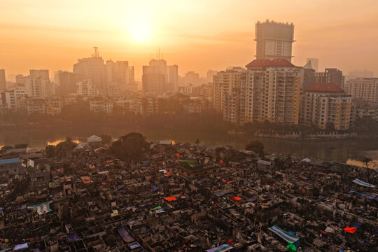 Aerial view of the dense Korail Basti informal settlement with makeshift structures and narrow alleys, contrasted against the modern high-rise skyline of Dhaka, Dhaka Division, Bangladesh.
