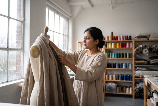 Indian fashion designer draping organic linen in a textile studio