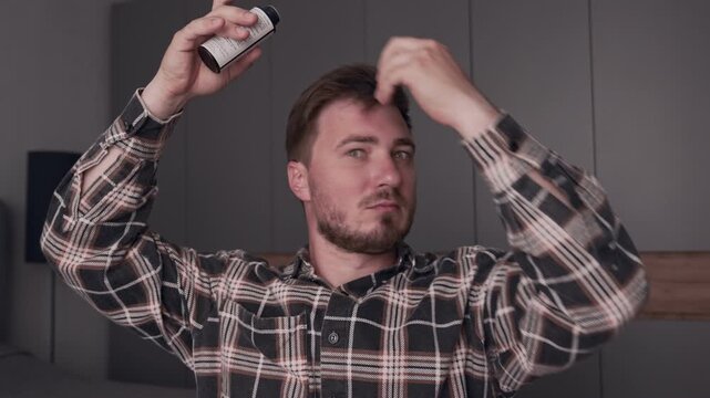 A man at home does his hair, I sprinkle styling powder on my hair, at home. Hair fixation with a special powder.