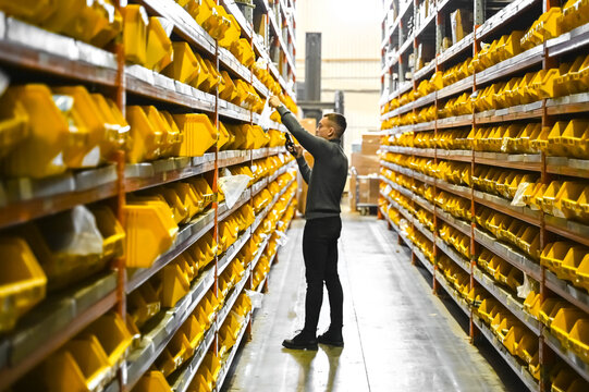 Industrial warehouse with small parts neatly stored in yellow storage bins. Organized inventory system for manufacturing, logistics, and spare parts management.
