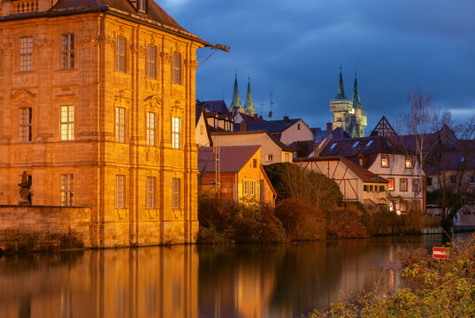 Traditional riverside houses reflected in the Regnitz River during blue hour in the historic center of Bamberg, Bavaria, Germany.