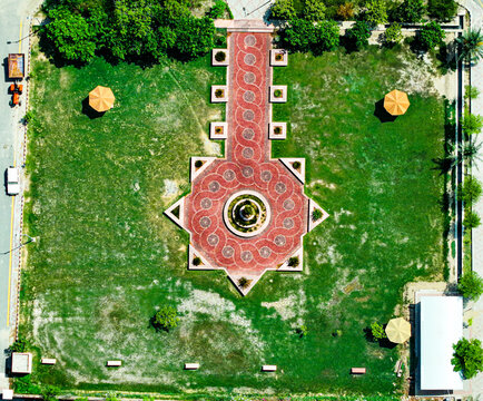 Aerial view of the landscaped courtyard at Ghazi University with a geometric red brick pattern and central fountain surrounded by green lawns in Dera Ghazi Khan, Punjab, Pakistan.