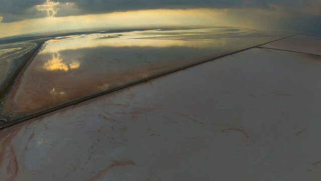 Aerial view of Koyuncu Salt Works at Tuz Golu with vast salt pans reflecting the golden hour sky in Sereflikochisar, Ankara, Turkiye.