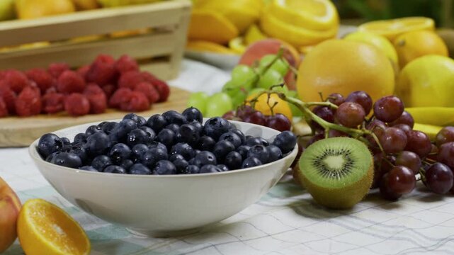 Delicious, diverse fresh fruit scattered across kitchen counter - tracking shot