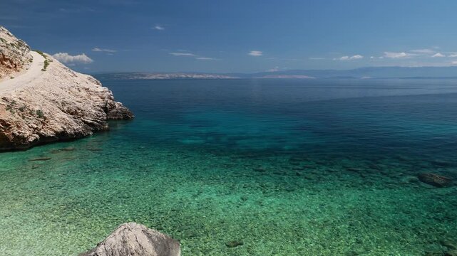 Mali Bok Beach, Cres Island, Croatia. Hidden Adriatic cove with turquoise water, rocky seabed, and steep cliffs.