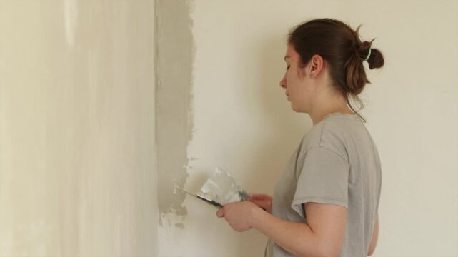 Painter aligning interior wall corner with angled trowel