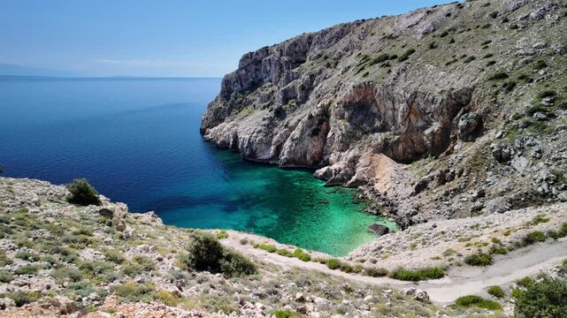 Mali Bok Beach on Cres Island, Croatia. Hidden cove with turquoise Adriatic Sea, dramatic limestone cliffs and crystal water surrounded by unspoiled Mediterranean nature in Cres Island of Croatia