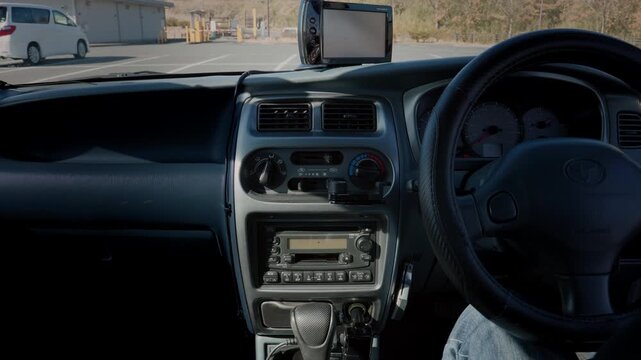 Interior of a Retro Compact Car With Full Dashboard. A Hand Inserts a Cassette Tape Into the Vintage Car Audio System, Plays It, and Presses the Eject Button  |  Japan