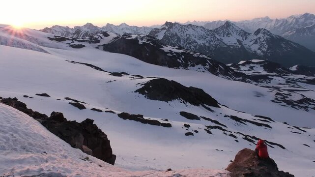 Tourist takes a photo of the sunrise on Mount Elbrus, view of the mountains from the slope of Mount Elbrus, Russia