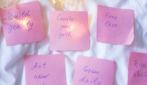Pink sticky notes featuring handwritten psychological growth messages on a cozy holiday background