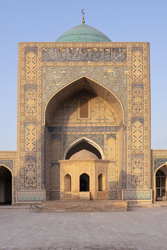 Kalyan Mosque ornate iwan portal with turquoise dome in Bukhara, Uzbekistan. Symmetrical facade decorated with intricate tilework, ideal for travel and heritage publications.
