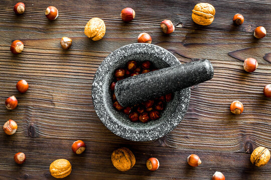 nuts in mortar for making spices in food set on wooden background top view