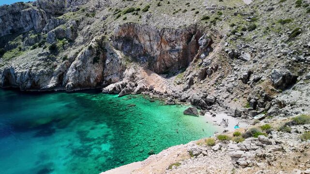 Mali Bok Beach, Cres Island, Croatia. Hidden Adriatic cove with turquoise water, rocky seabed, and steep cliffs.