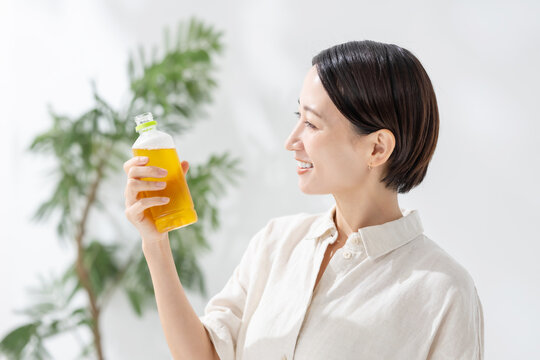 ペットボトルのお茶を飲む女性