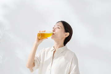 Fototapeta premium ペットボトルのお茶を飲む女性
