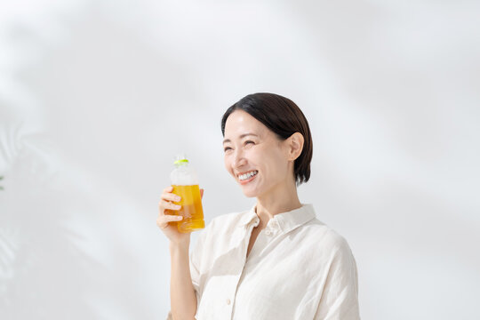 ペットボトルのお茶を飲む女性