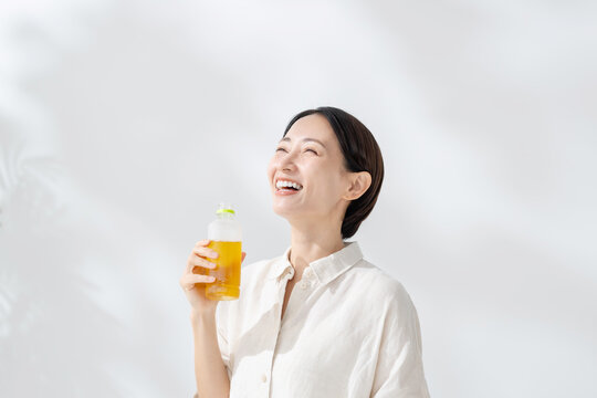 ペットボトルのお茶を飲む女性