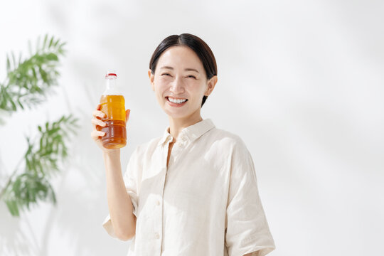 ペットボトルのお茶を飲む女性