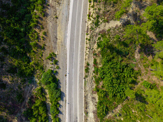 Obraz premium Top down aerial view of new road construction through rugged terrain