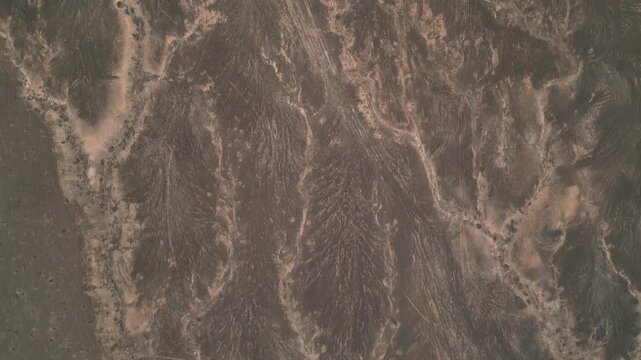 Aerial view of the arid volcanic landscape with intricate erosion patterns and textured terrain near El Cotillo, Canary Islands, Spain.
