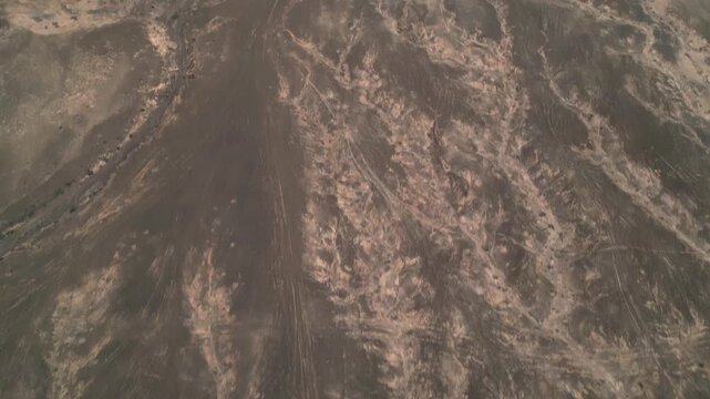 Aerial view of the rugged volcanic landscape and arid terrain surrounding the coastal village of El Cotillo, Canary Islands, Spain.