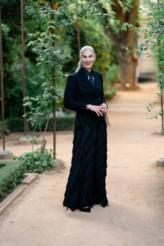 Graceful mature woman standing. Sophisticated senior woman in traditional evening attire