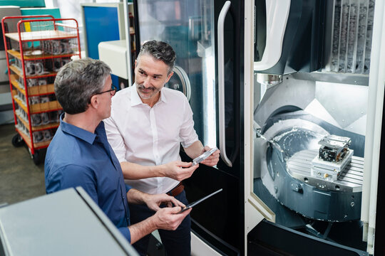 Businessmen in factory, having a meeting, discussing solutions