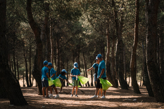 Group of volunteering children collecting garbage in a park