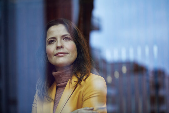 Portrait of confident businesswoman looking out of window