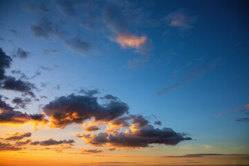 bright orange rays of the sun illuminate the clouds at sunset © dmitr1ch