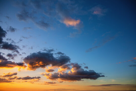 bright orange rays of the sun illuminate the clouds at sunset