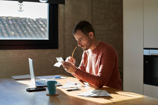 Man analyzing financial bills at home