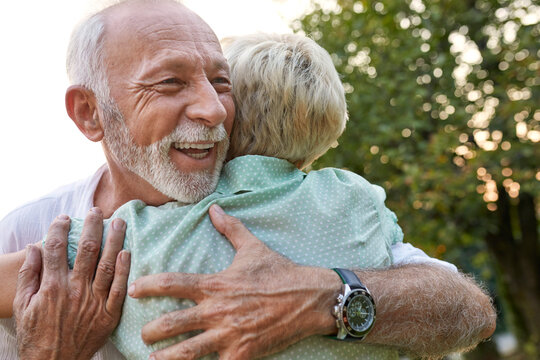 Happy senior couple hugging outdoors