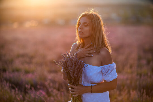 Woman lavender bouquet golden hour portrait expressing peaceful emotion in sunlit field