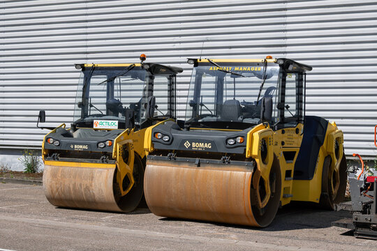 Nancy, France - July 4th 2026 : View on a yellow tandem roller Bomag BW 206 AD-5 AM for compacting asphalt on a road during road works alongside another roller.
