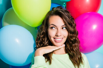 Obraz premium Smiling young woman posing with colorful balloons in a cheerful portrait expressing celebration, joy and playful party lifestyle vibes